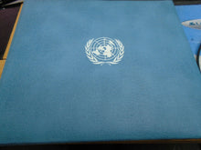 Load image into Gallery viewer, 1975 - 77 UNITED NATIONS OFFICIAL SILVER PROOF MEDAL COVER WITH STAMPS IN SLEAVE
